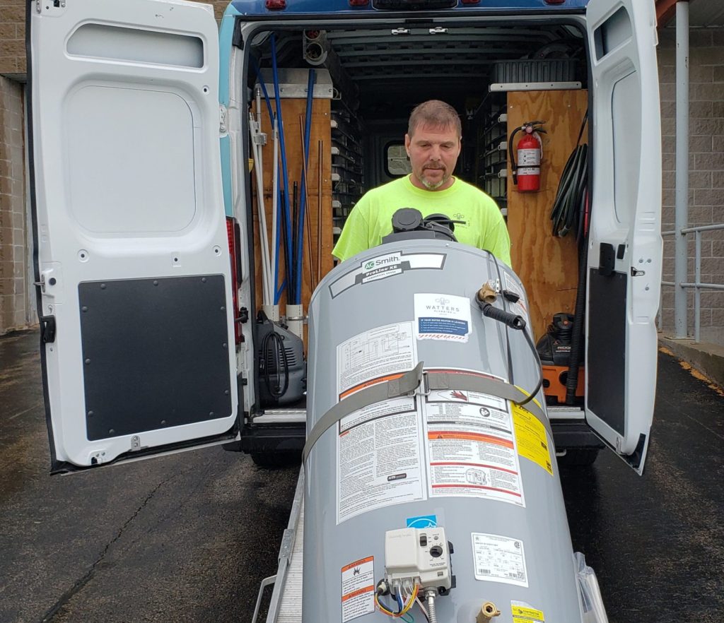 Watters Plumbing's employee loading a water heater into a van for a Northeast Wisconsin home