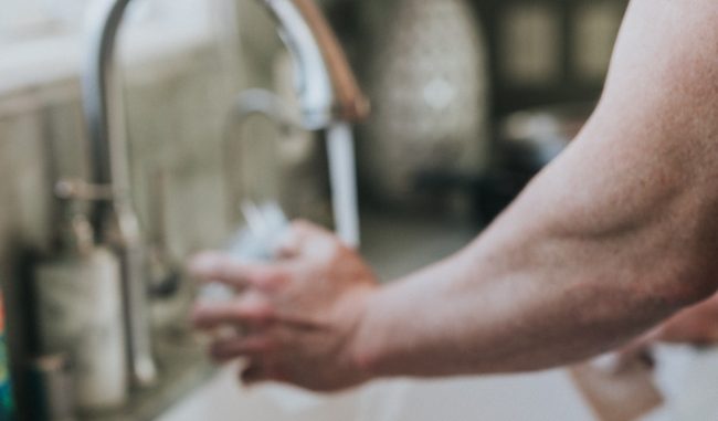 person by their kitchen sink