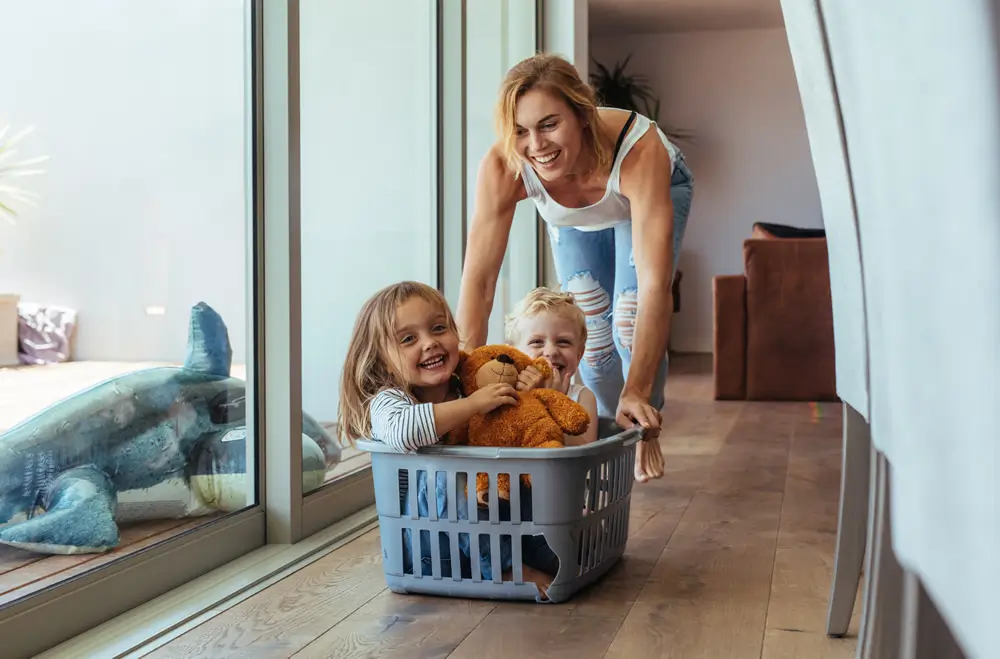 Mother with kids having fun in laundry basket