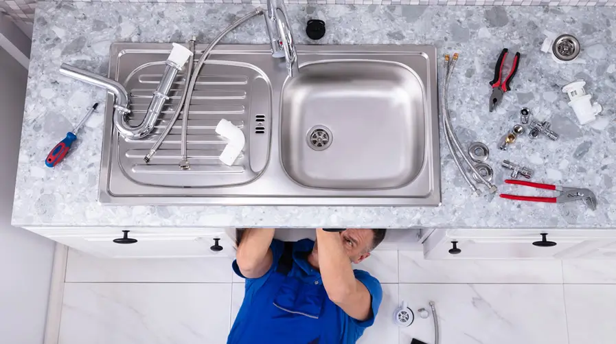 Plumber working on kitchen sink